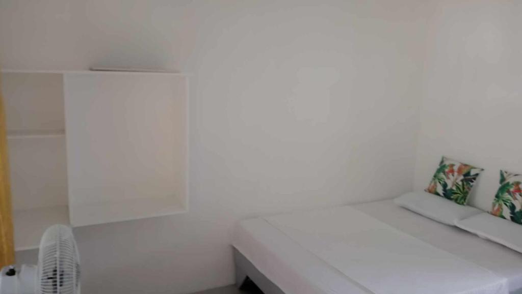 波尔多·格尼拉Kaye En Em Apartelle的配有风扇的客房内的白色长凳