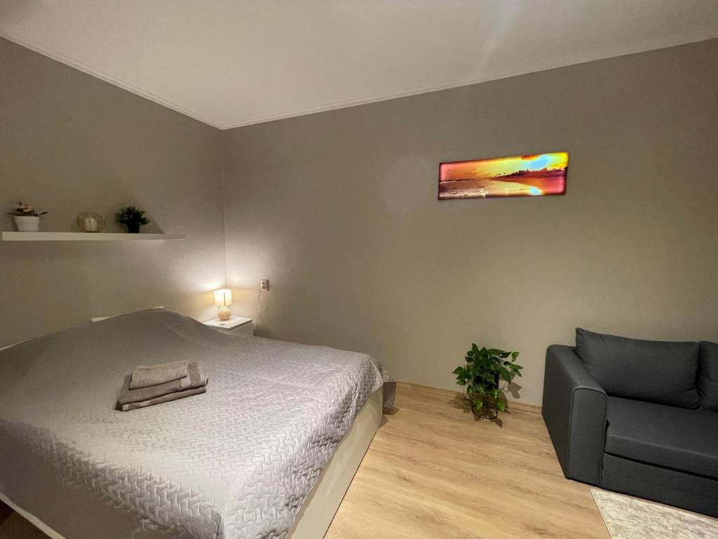 里加Cozy apartment close to Riga Airport的一间卧室配有一张床和一把椅子