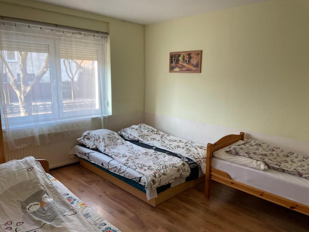 布达佩斯红色机车公寓 的带窗户的客房内的两张床