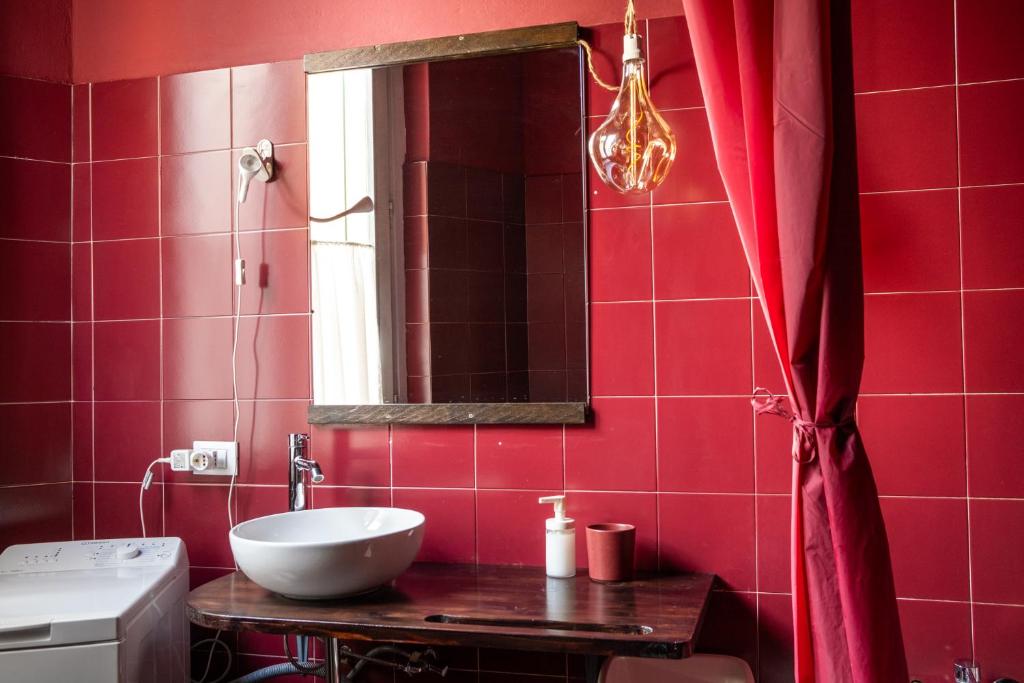 克雷马L'eco della rosa的红色的浴室设有水槽和镜子