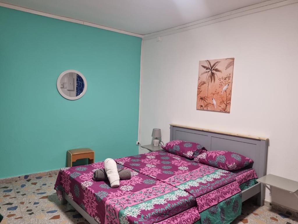 PamandziSTARALOGE的一间卧室配有一张带粉红色床罩的床