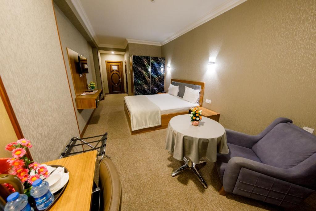 巴库Royal Boutique Baku的酒店客房配有床、沙发和桌子。