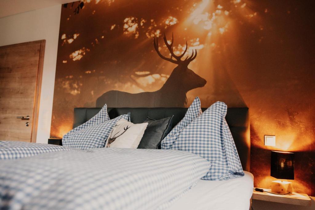 伦格里斯Wohnung Schrödelstein的卧室配有一张床铺,墙上挂着鹿的照片