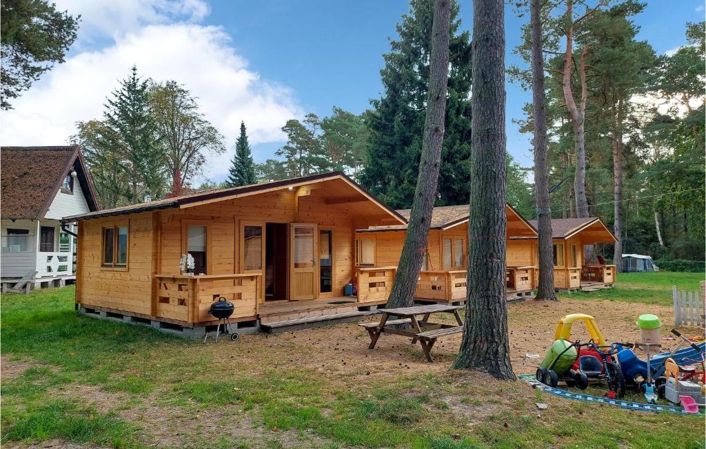 波别罗沃Beautiful Home In Pobierowo With Kitchen的树林中的小木屋,设有游乐场