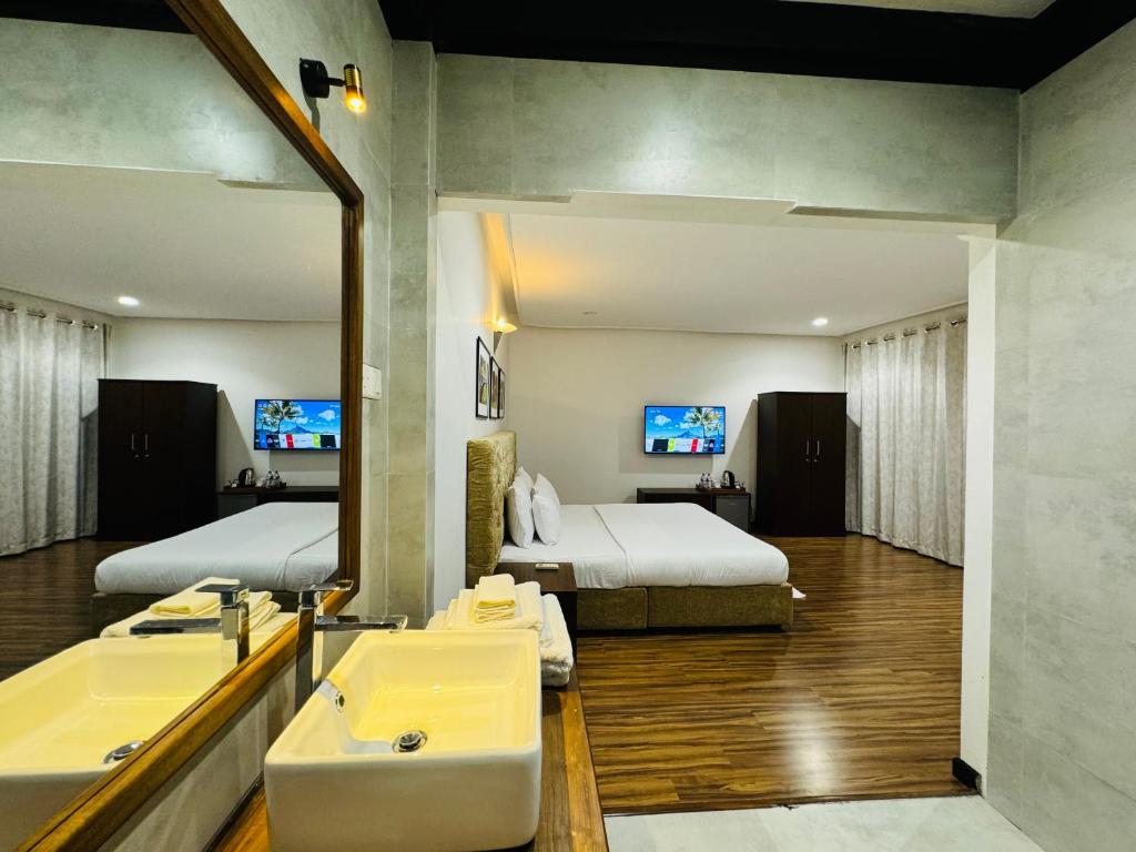 米瑞莎Beverly Beach Mirissa的浴室设有两张床、一个水槽和镜子
