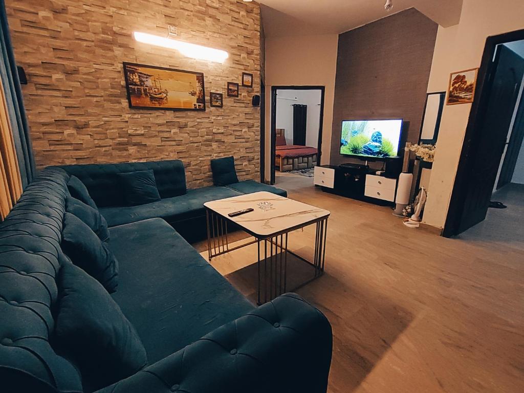 伊斯兰堡APARTMENTS of Comfort!的客厅配有蓝色的沙发和桌子