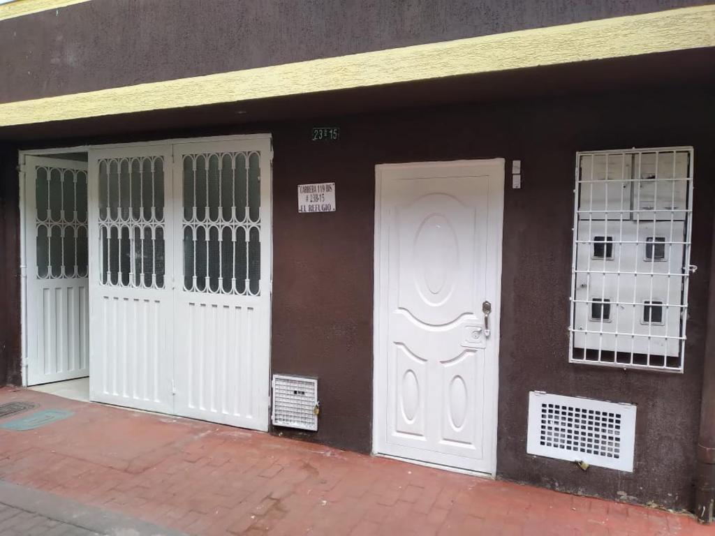 波哥大El descanso的一座建筑,有三个白色门窗