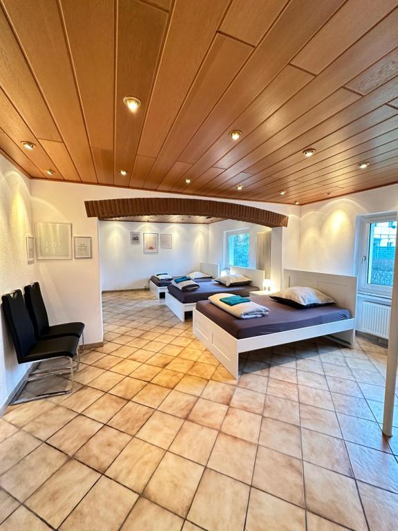 比勒费尔德Spacious Large apartment in Bielefeld的大房间设有四张床和木制天花板