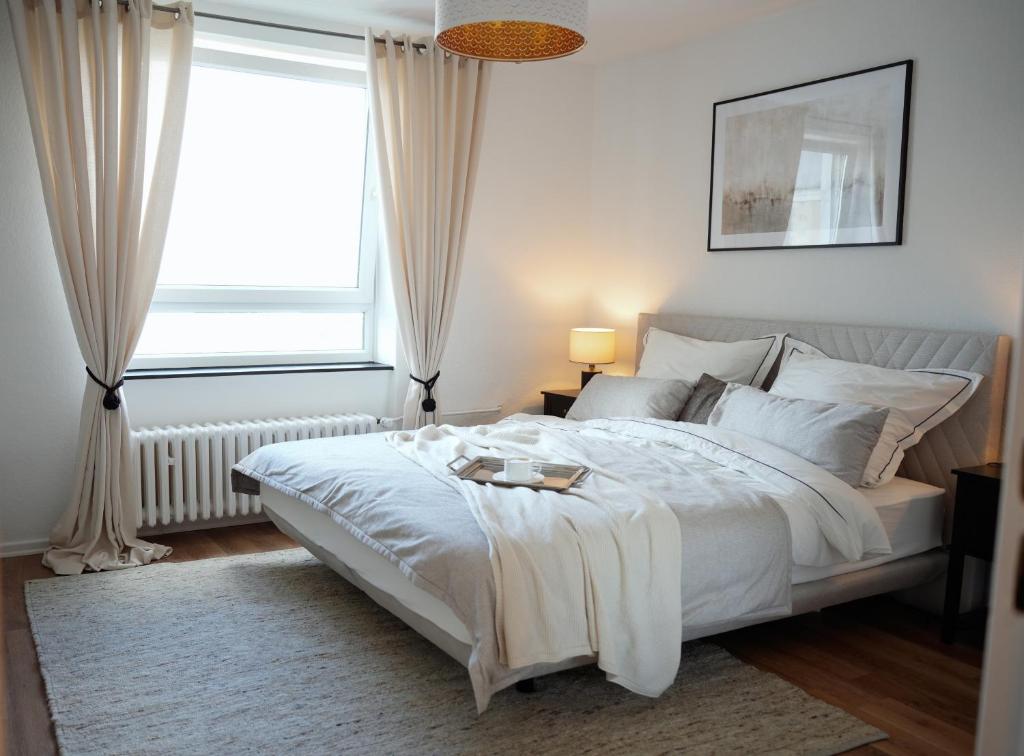 汉诺威Elegantes & Modernes Messe Apartment, Hannover, Laatzen的卧室配有一张大白色床和窗户