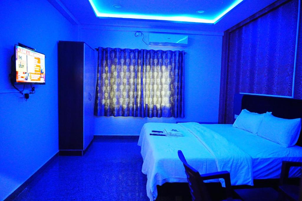 班加罗尔LEE PARADISE INN的蓝色的房间,配有床和电视