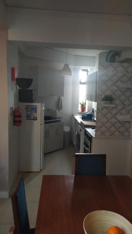 卡帕里卡海岸Daloba House的一间带桌子的厨房和一间带冰箱的厨房