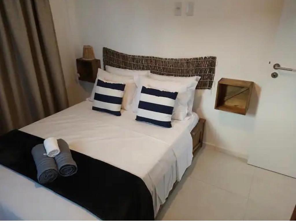 圣米格尔-杜斯米拉格里斯Casa TUA的一间卧室配有一张带蓝色和白色枕头的床