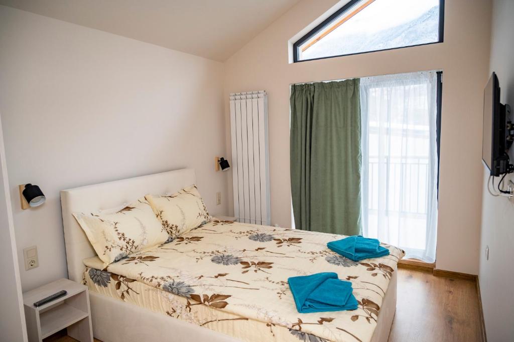 萨帕雷瓦巴尼亚Villa Doma的一间卧室配有一张带蓝色毛巾的床