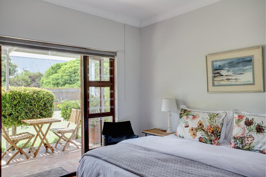 赫曼努斯Beautiful Abalone的一间卧室设有一张床和一个滑动玻璃门