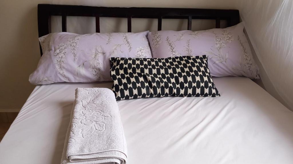 恩德培Mini Lookout Entebbe的一张带两个枕头的床和两条毛巾