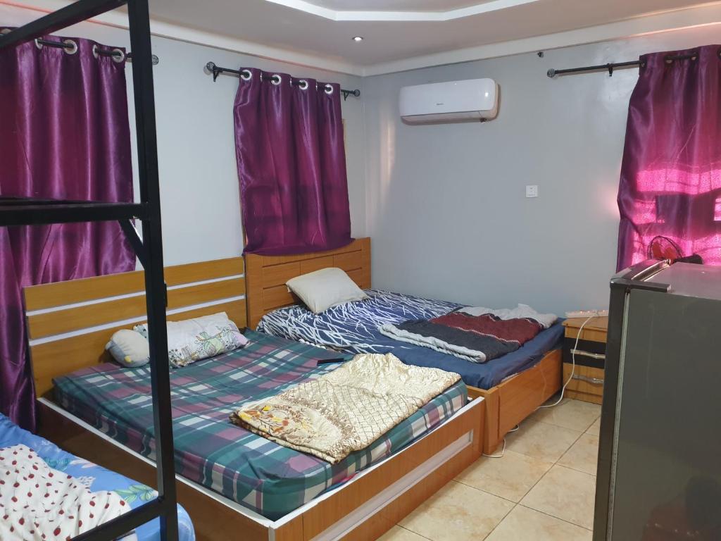 WupaShared space accommodation的一间卧室设有两张双层床和紫色窗帘