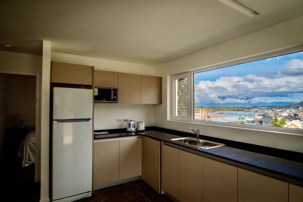 乌斯怀亚Ushuaia Center Apartament Suit的厨房配有白色冰箱和大窗户