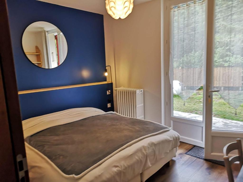 AvajanLe Relais d'Avajan的一间卧室设有蓝色的墙壁和镜子