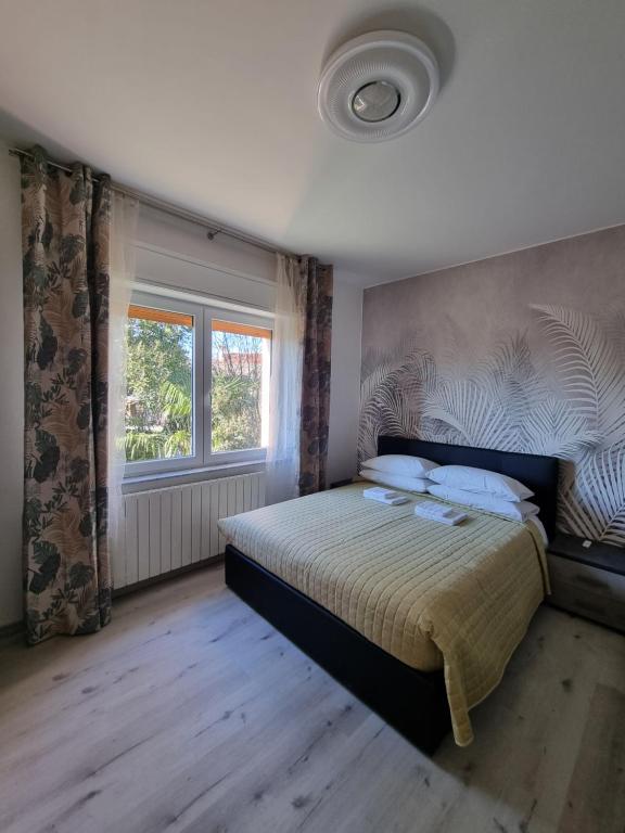 Bilocale Villesse的一间卧室设有一张床和一个窗口