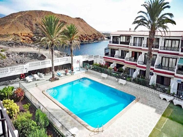 德尔锡伦西奥海岸Sasha Tenerife的棕榈树建筑前的游泳池