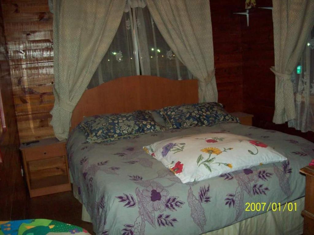 圣安东尼奥Hosteria Algarrobo的一间卧室配有一张带鲜花枕头的床