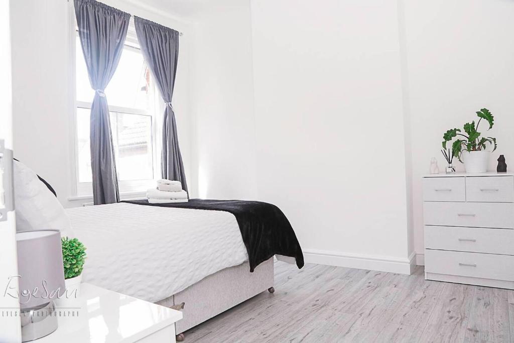 布罗姆利Inviting 3-Bed Apartment in Bromley的白色的卧室设有床和窗户