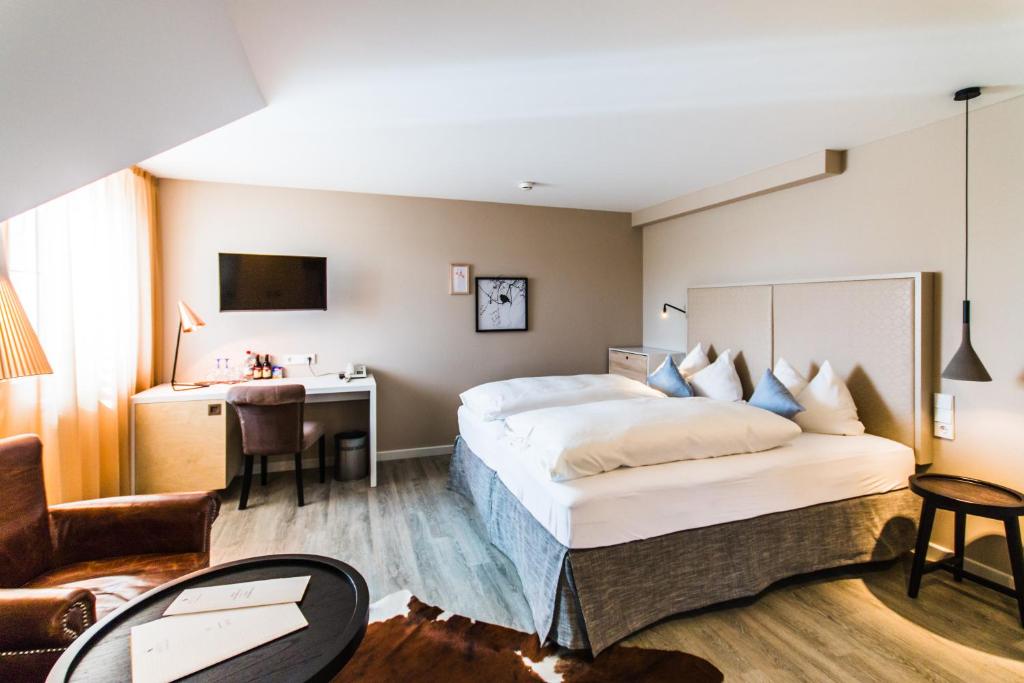 腓特烈港诺布洛克酒店的酒店客房设有一张大床和一张书桌。