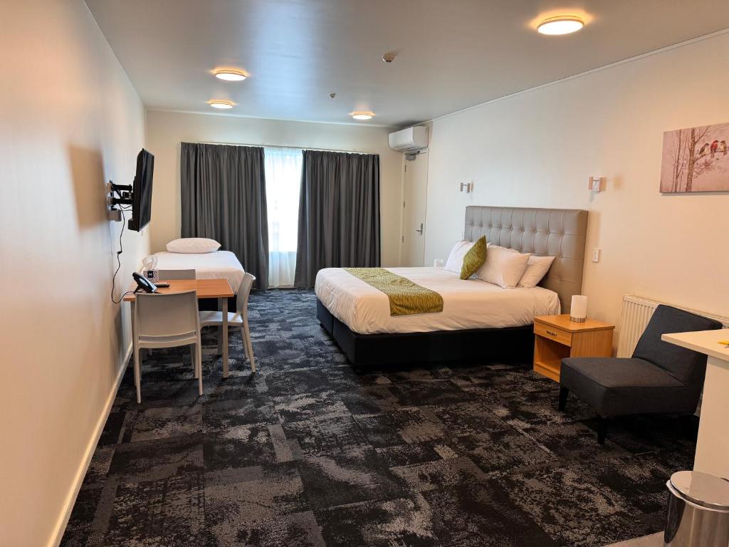 汉密尔顿Zeta Motel的配有一张床和一张书桌的酒店客房