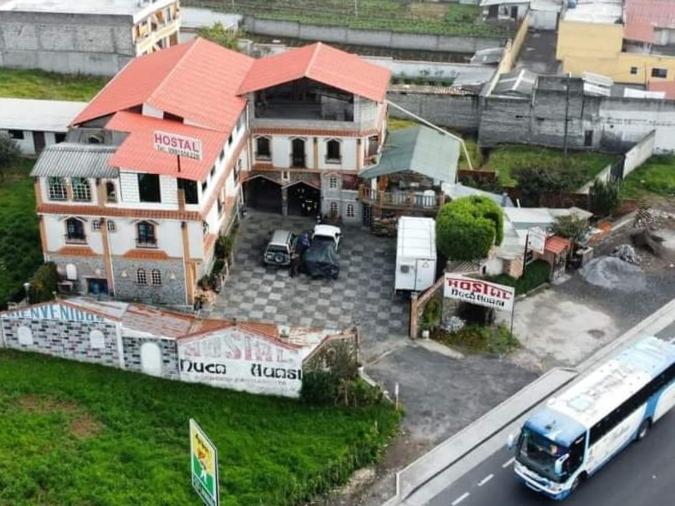 TambilloHostal Ñuca Huasi的一辆大房子前面停有一辆公共汽车