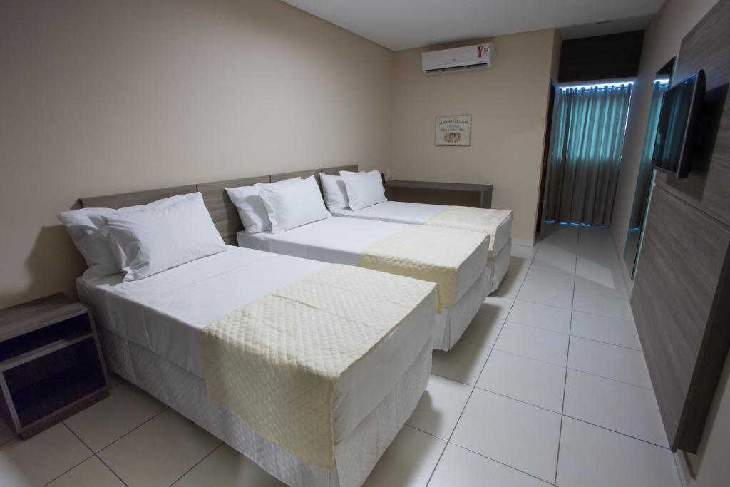 托里塔马Toritama Golden Hotel的酒店客房设有两张床和电视。
