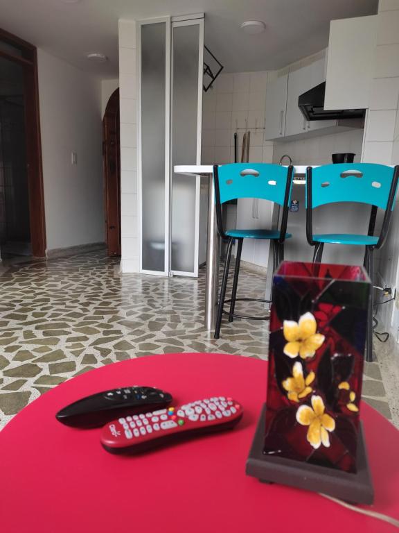 马尼萨莱斯Bonito apartamento con excelente ubicación的红色地毯上带两个遥控器的桌子