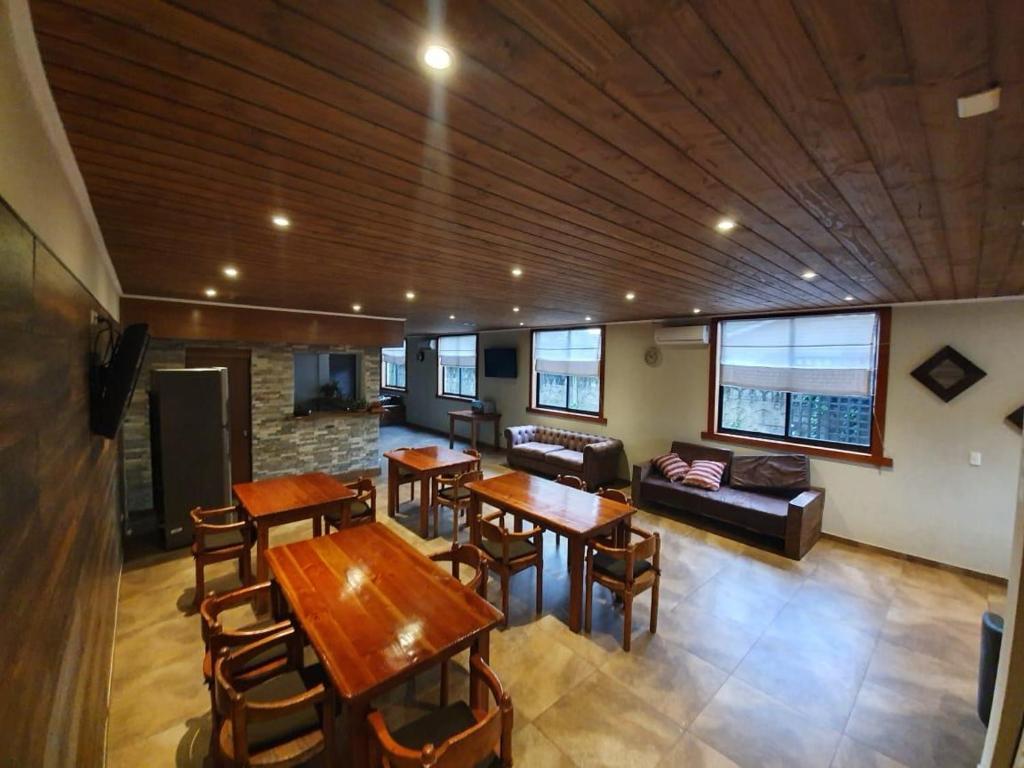 比亚里卡Hotel Villarrica Centro的客厅配有桌椅和沙发