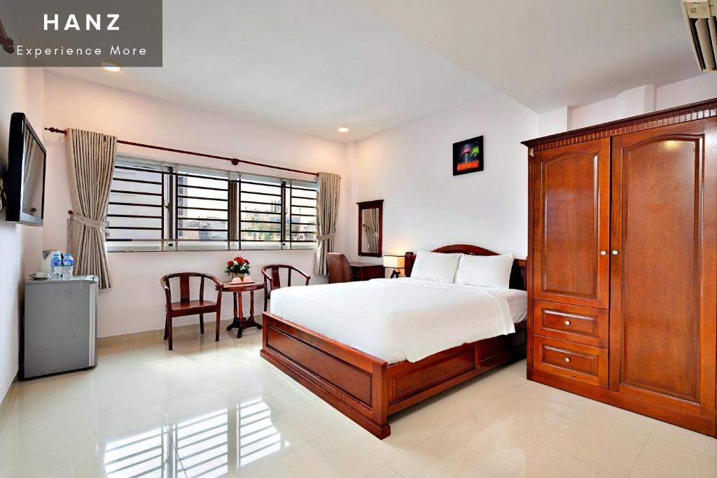 胡志明市HANZ Hoang Hoang Hotel Ben Thanh的一间卧室配有一张大床和一张桌子