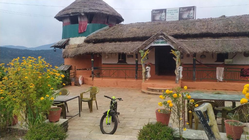 博卡拉Astam farm house homestay的停在鲜花房子前面的自行车