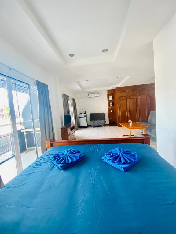 卡塔海滩BT hotel Kata Beach的一间卧室配有蓝色的床和蓝色枕头