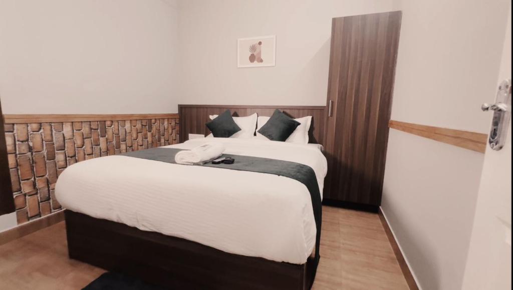KaniyāmbettaEasy Inn Wayanad的一间卧室配有两张带白色床单的床