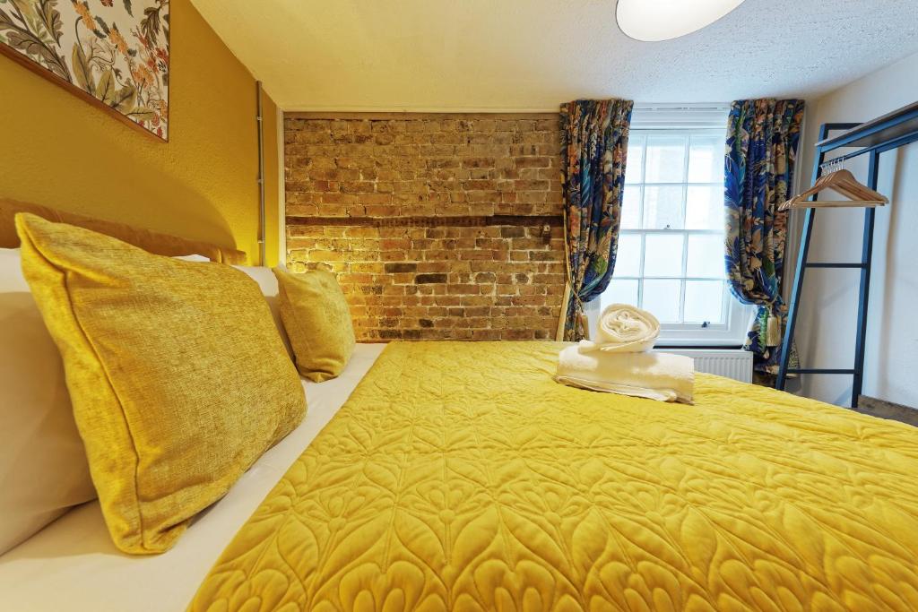 马盖特Northern Belle four Bedroom Apartment的一间卧室设有一张带砖墙的大床