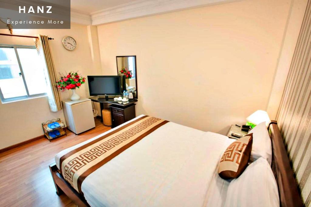 胡志明市HANZ Thanh Thu Hotel的一间卧室配有一张床和一台电视