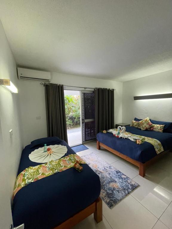 苏瓦Island Accommodation Suva Premier Hospitality的一间卧室设有两张床和窗户。