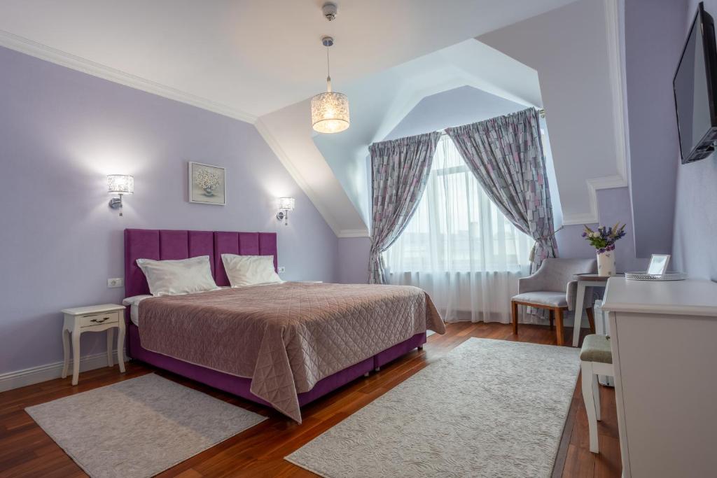 德瓦Vila Missy的一间卧室设有紫色的床和窗户