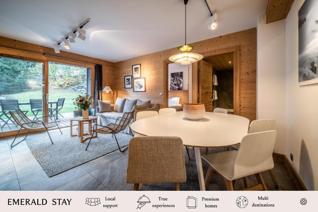 里雾诗Apartment Valvisons Les Houches Chamonix - by EMERALD STAY的用餐室以及带桌椅的起居室。