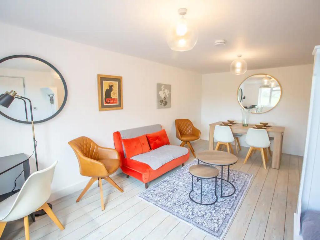 基德灵顿Pass the Keys Stylish apartment in peaceful Oxfordshire suburb的客厅配有红色的沙发和桌子