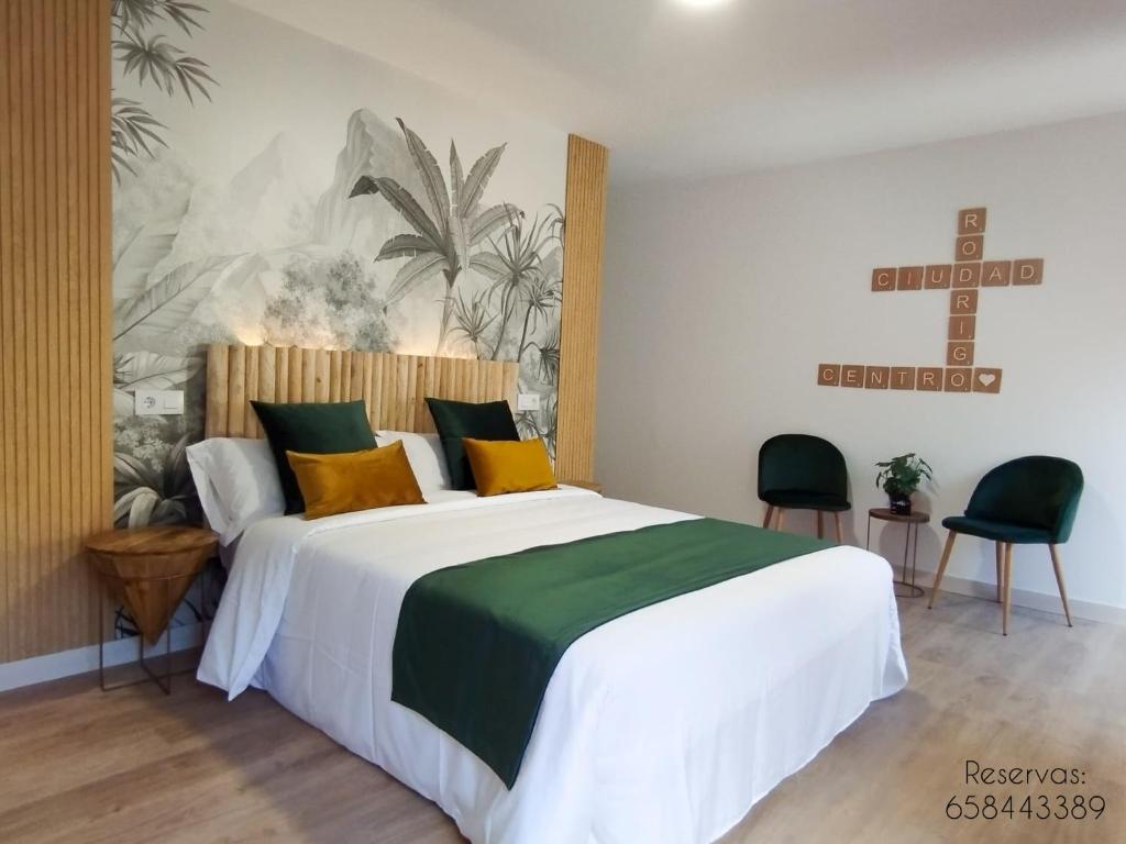 罗德里戈城Ciudad Rodrigo Centro的一间卧室配有一张大床,提供黄色和绿色的枕头
