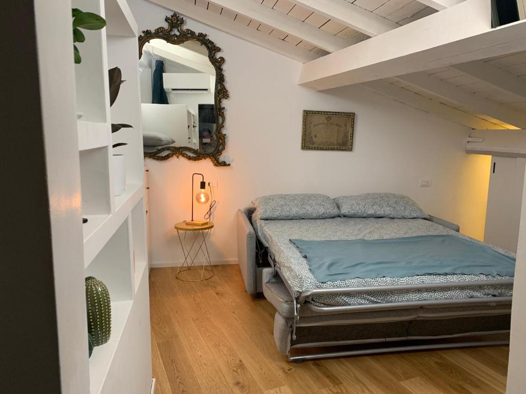 萨沃纳Via Pia 29-7的卧室配有一张床,墙上设有镜子
