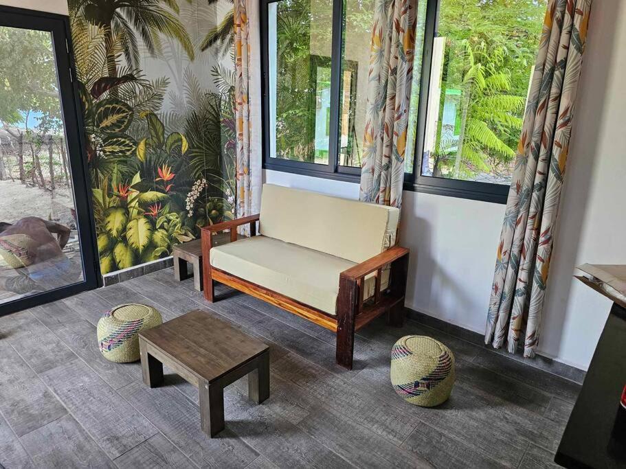 AndjamenBungalow Ramena beach Antsiranana的客厅配有长凳和桌子