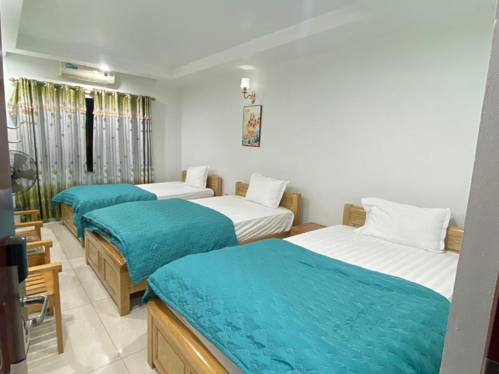河内Đức Hiếu 1的带三张床和蓝色床单的客房