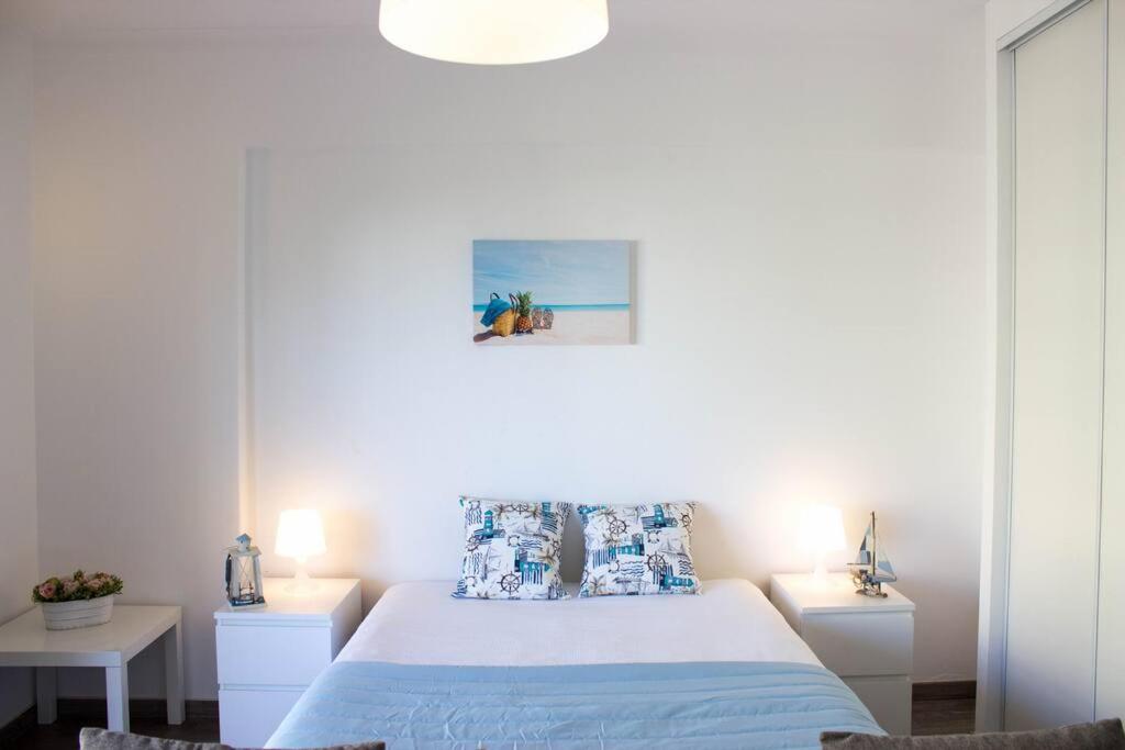 波尔蒂芒Casa dos Arcos BeachStudio by CC 904的一间白色卧室,配有一张床和两张桌子