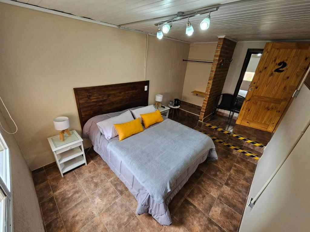 埃尔卡拉法特SOUL B&B的一间卧室配有一张带两个黄色枕头的床