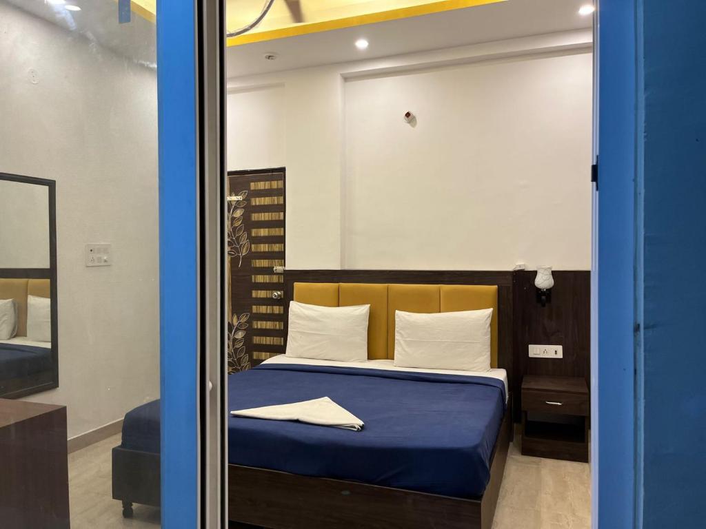 戈勒克布尔ARNAV GUEST HOUSE的一间卧室配有一张带蓝色床单和镜子的床