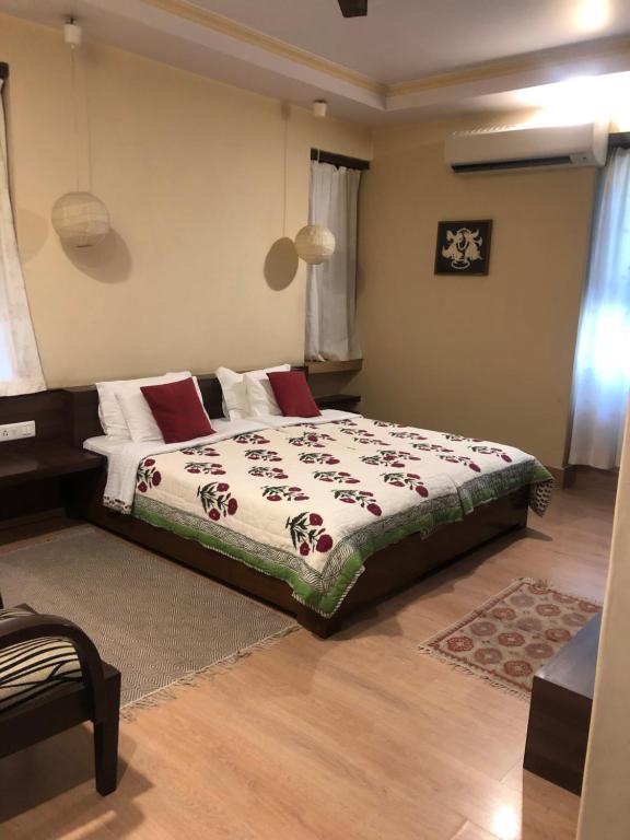 斋浦尔喜鹊维拉酒店的一间卧室配有一张带红色枕头的大床